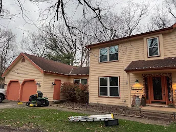 Two-story home with holiday lights installed along the roofline in daylight