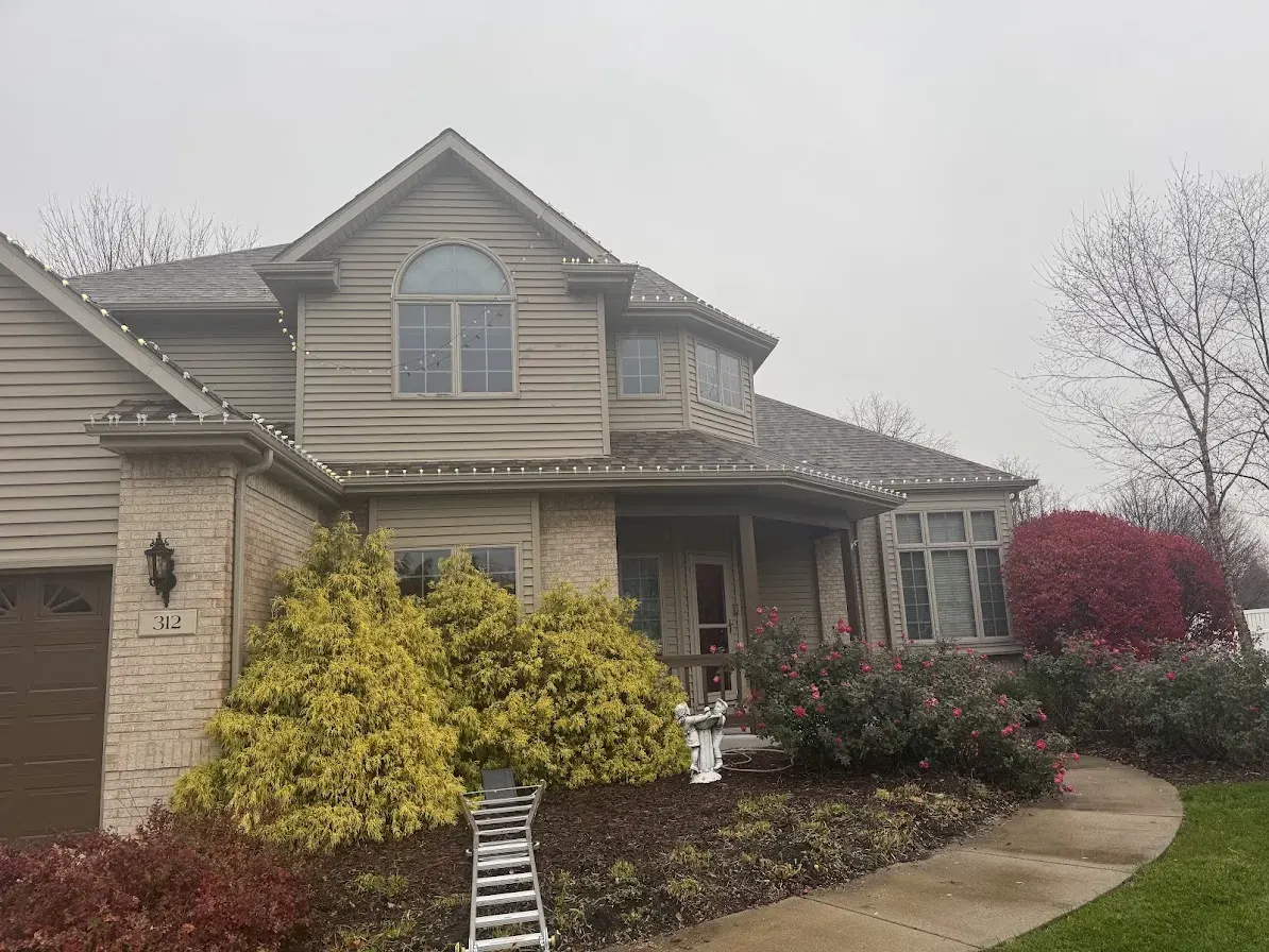 Two-story home with evenly spaced holiday lights across several rooflines